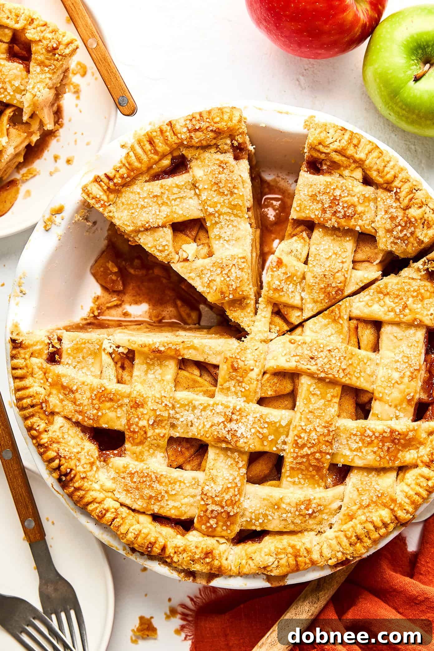 A whole homemade apple pie, freshly baked with a golden, flaky crust, ready to be sliced and served.