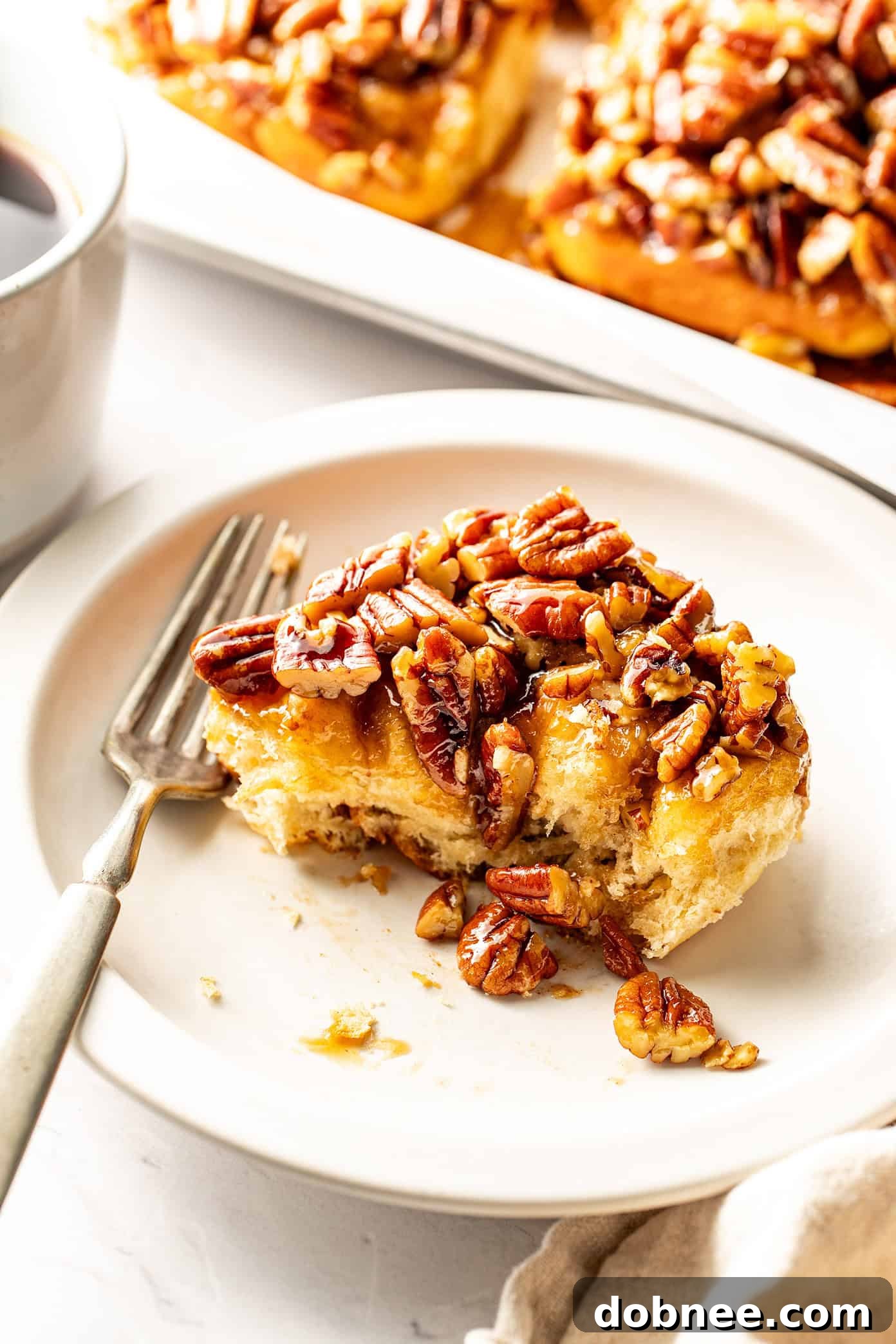 Golden brown maple pecan sticky buns with gooey caramel and toasted pecans on top, fresh from the oven