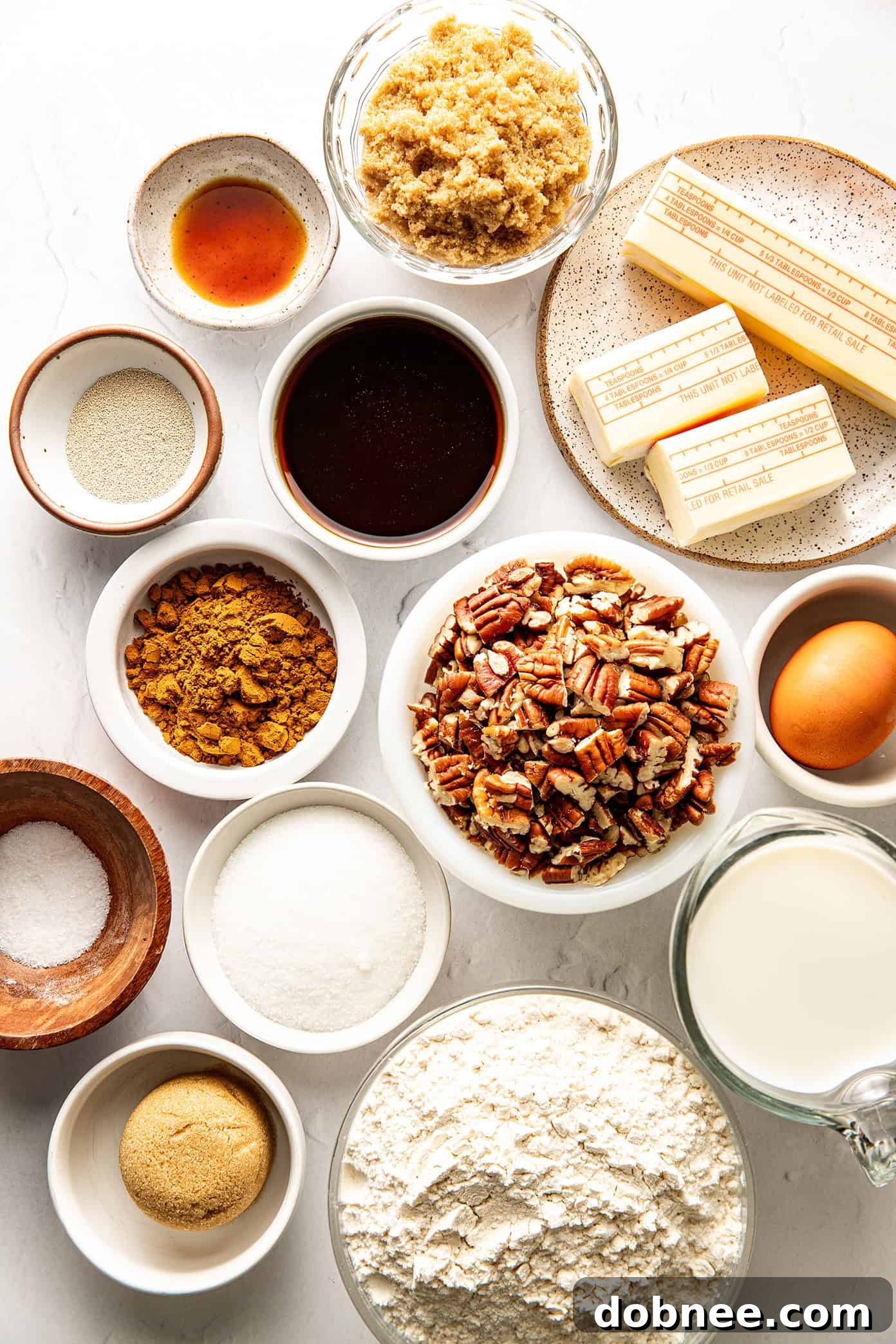 A pan full of freshly baked sticky buns, golden brown and glistening with a thick layer of caramel and pecans