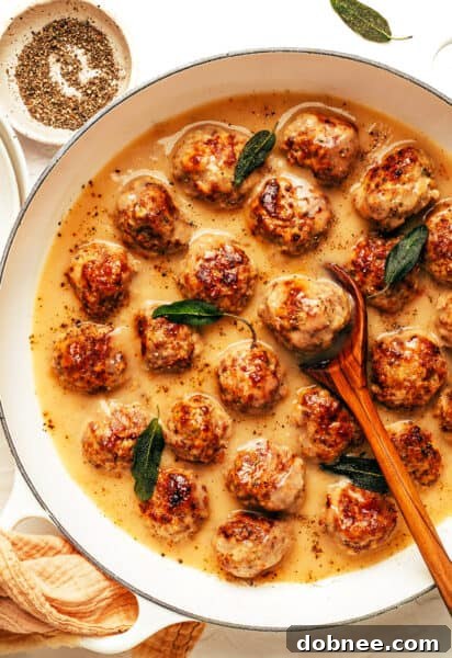 Close-up of golden brown turkey meatballs in a savory gravy, ready to be served.