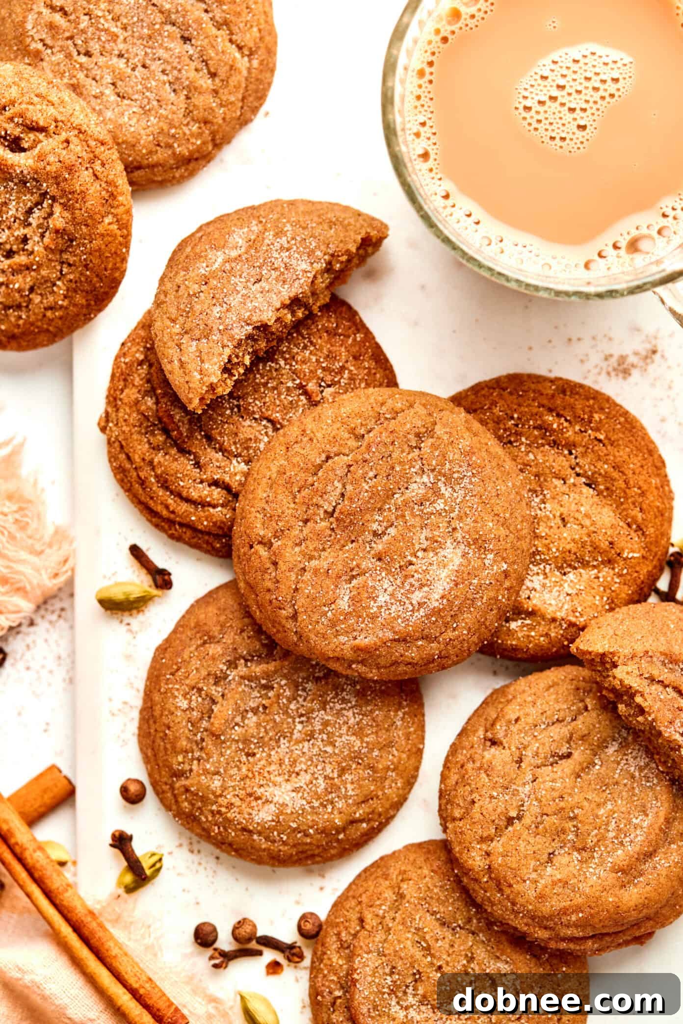A stack of golden brown chai cookies on a wooden board.