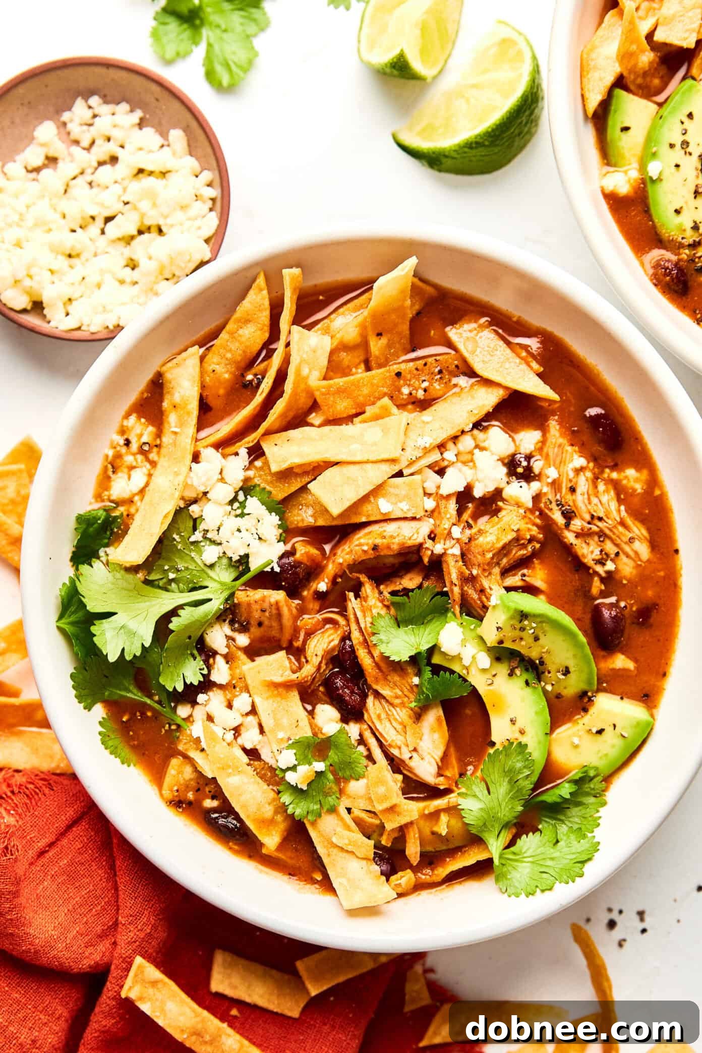 A steaming bowl of Turkey Tortilla Soup garnished with fresh cilantro and avocado slices, ready to be enjoyed.