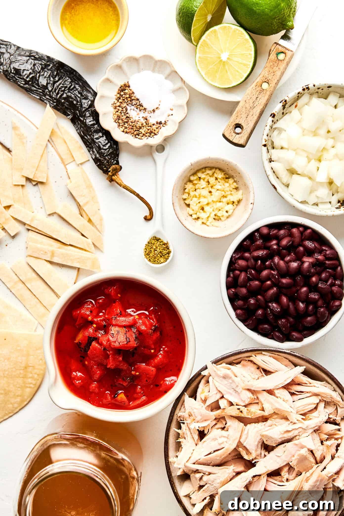 A vibrant bowl of turkey tortilla soup, showcasing the rich, reddish-brown broth and various toppings.