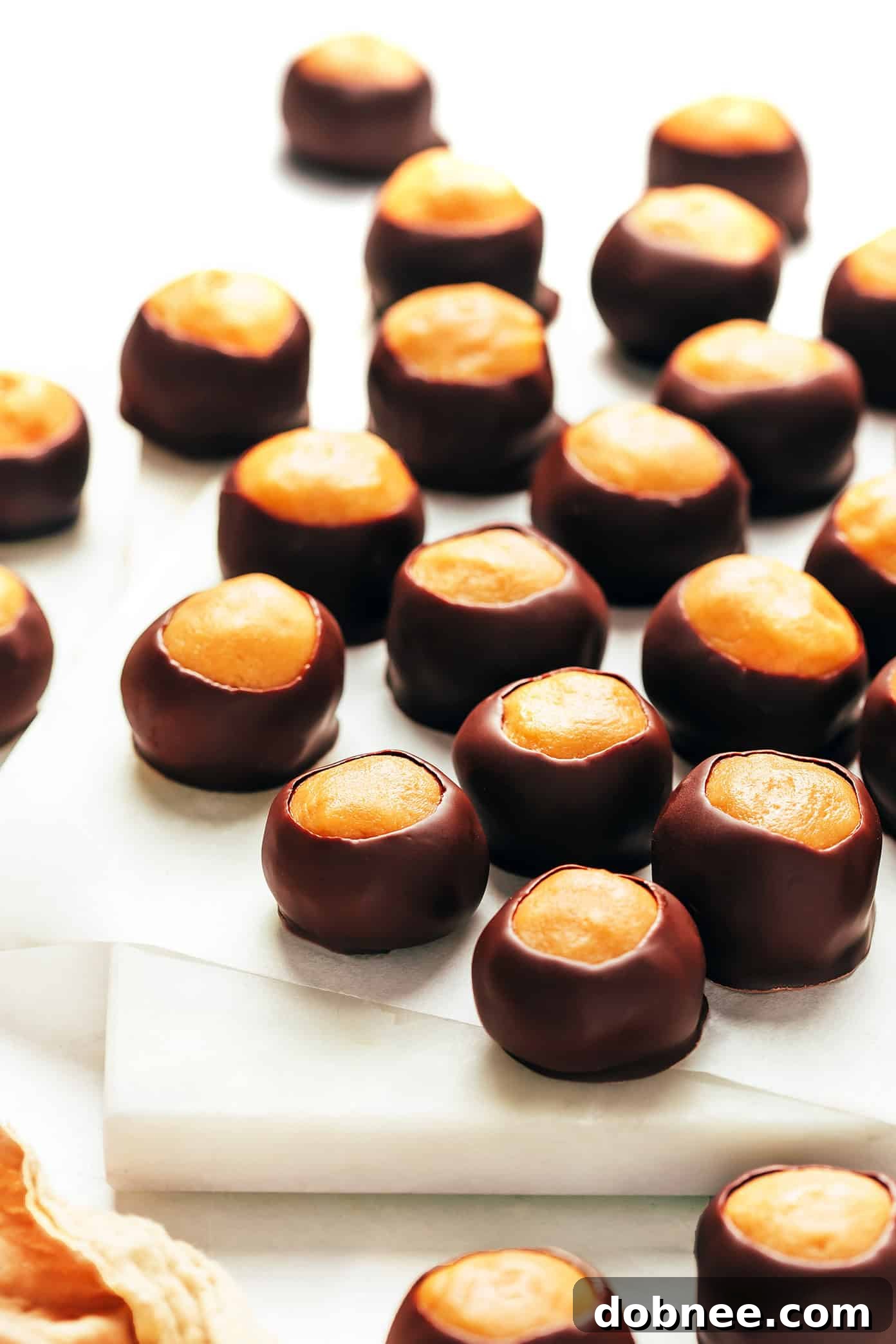 A beautifully arranged platter of finished buckeyes on a marble board, ready to serve.