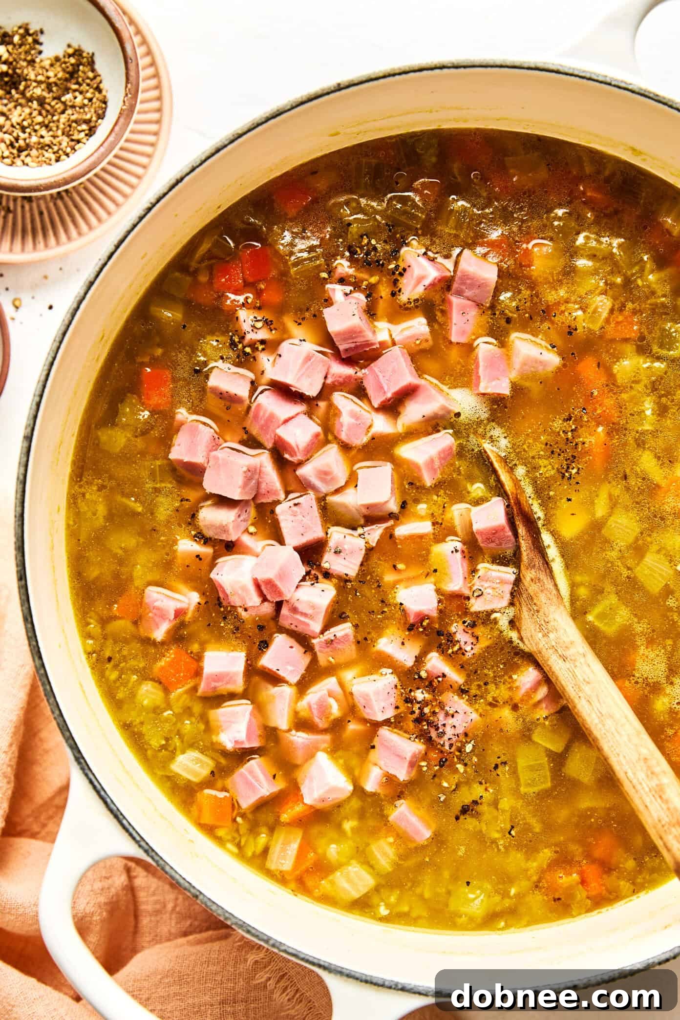 Ingredients for split pea soup laid out on a wooden cutting board.