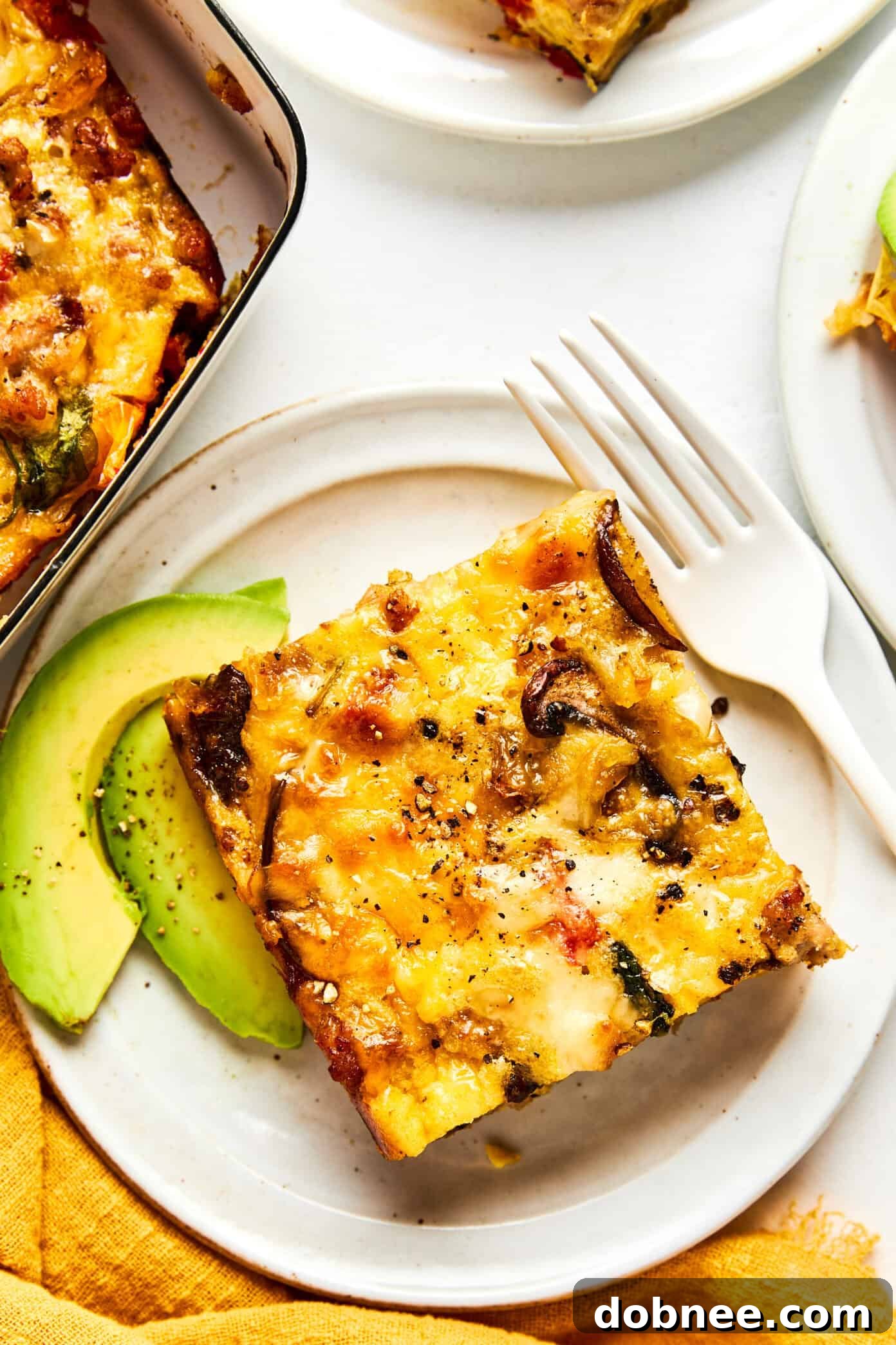 A close-up shot of a slice of breakfast casserole, showing the layers of ingredients.