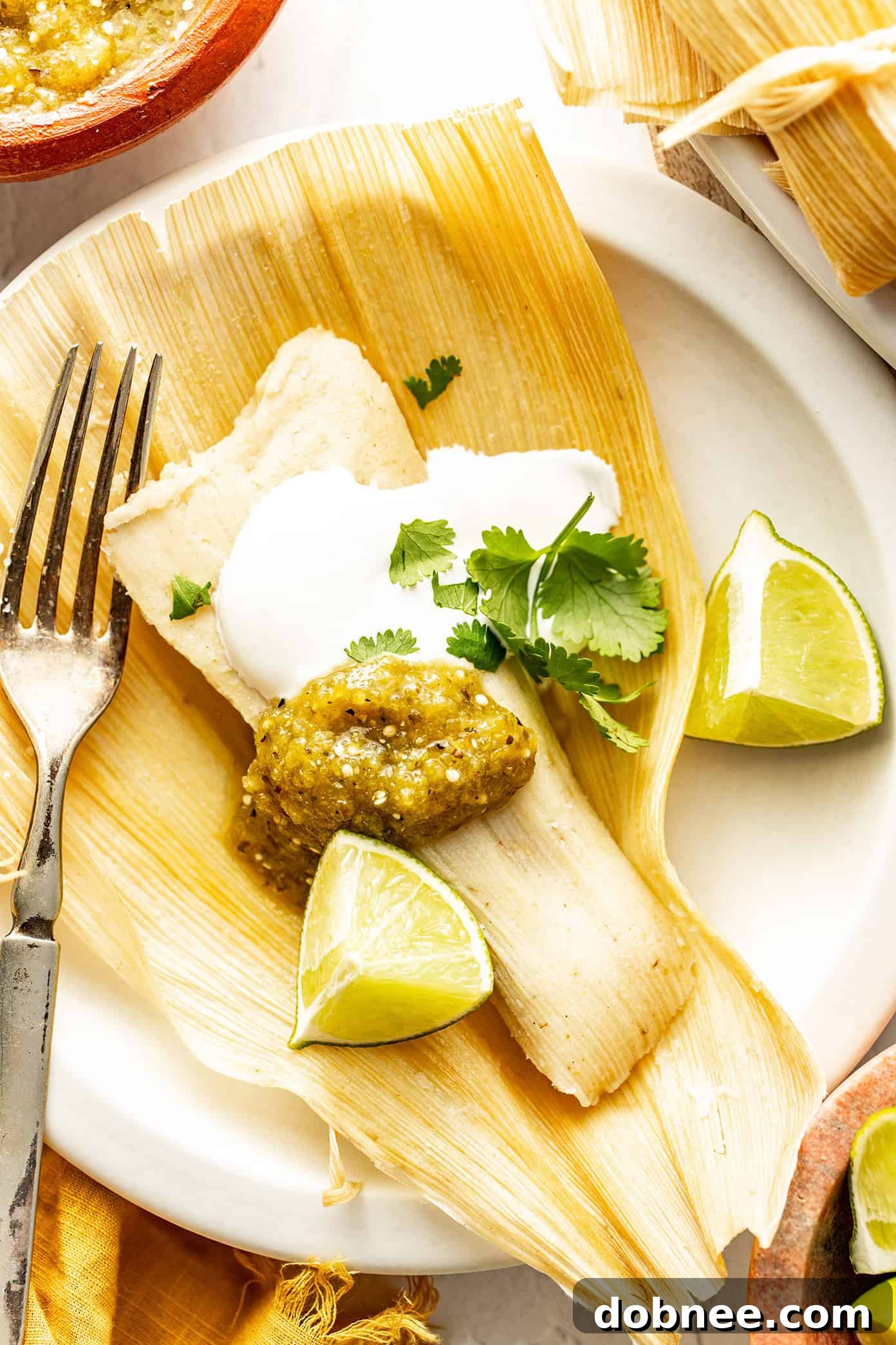 Green Chile Chicken Tamales 2 Delicious green chicken tamales stacked high with fresh salsa verde