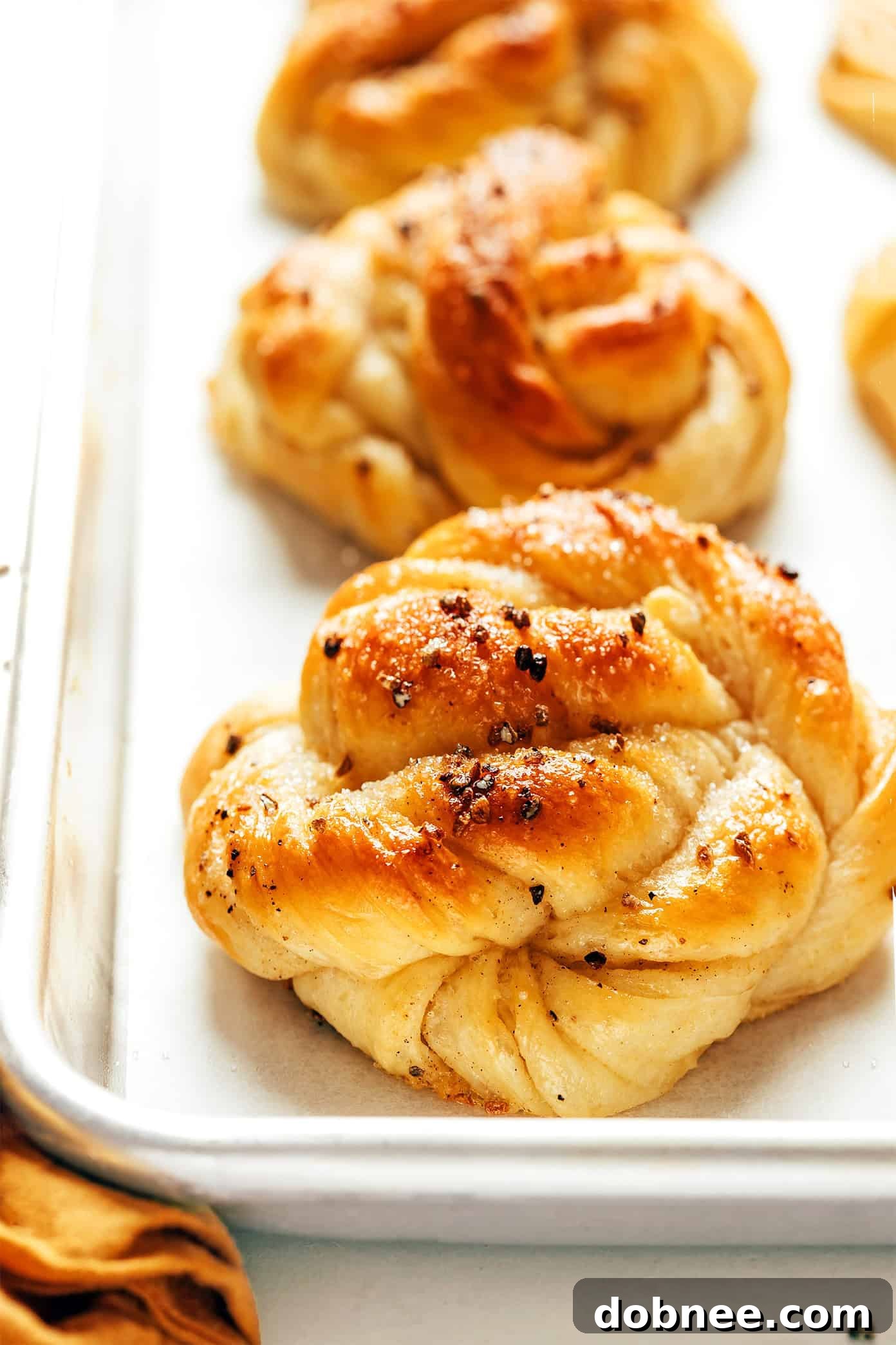 Freshly baked Swedish Cardamom Buns arranged beautifully on a cooling rack.