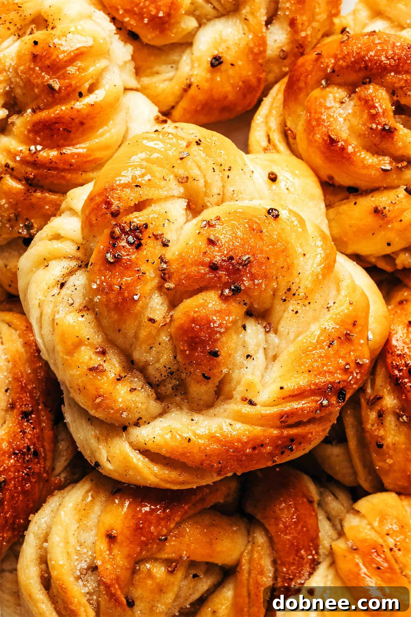 A warm, gooey cardamom bun being pulled apart to reveal its soft, layered interior.