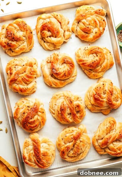 A close-up of a finished Swedish Cardamom Bun with a perfectly tied knot and pearl sugar.