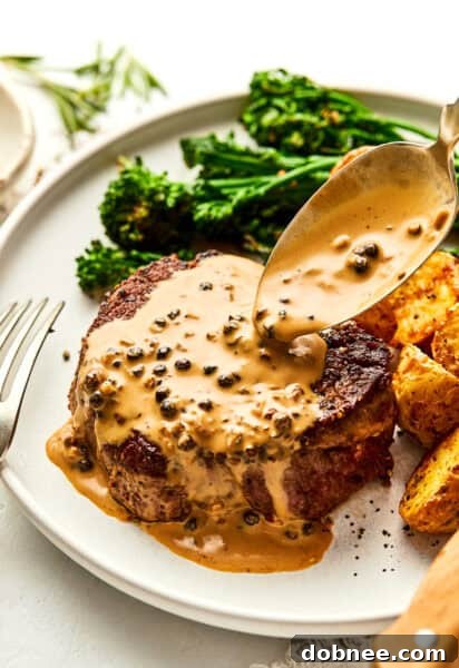 Filet Mignon with Peppercorn Sauce on a plate, garnished.