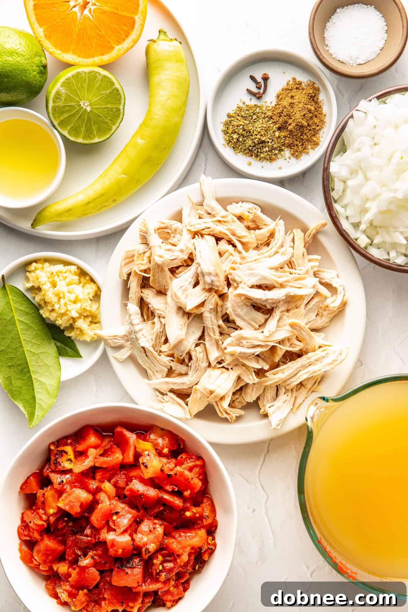 A close-up shot of a steaming bowl of Sopa de Lima, adorned with crispy tortilla strips, fresh lime wedges, and vibrant cilantro.