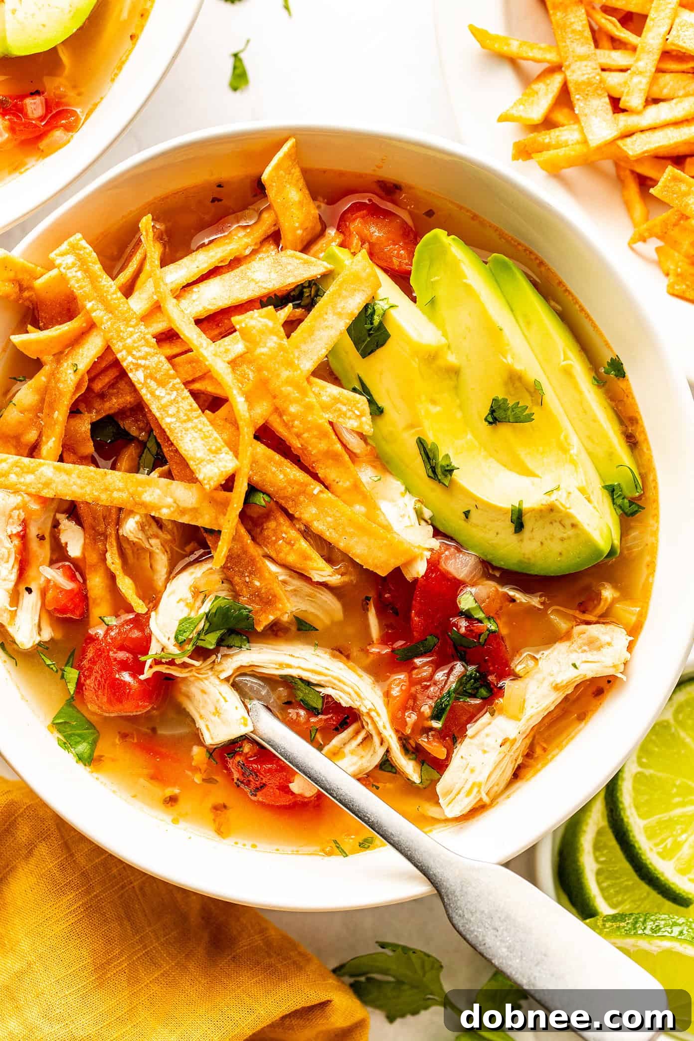 A vibrant and appealing bowl of Sopa de Lima, garnished with fresh toppings, ready for serving.
