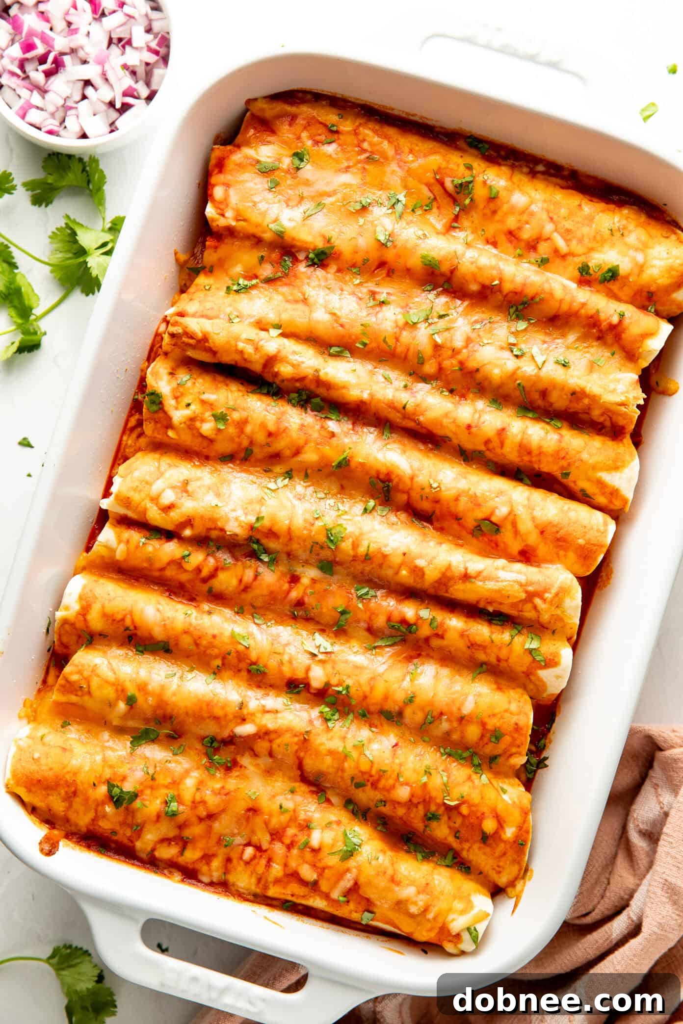 A serving of breakfast enchiladas on a plate with toppings