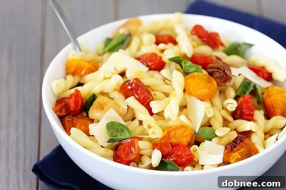 Pasta with Slow-Roasted Tomatoes, Garlic & Parmesan | gimmesomeoven.com Delicious pasta dish with slow-roasted tomatoes, garlic, and Parmesan cheese, garnished with fresh basil.