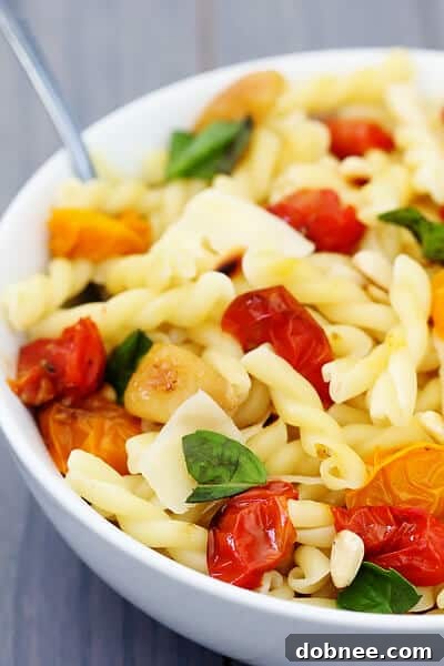 Pasta with Slow-Roasted Tomatoes, Garlic & Parmesan | gimmesomeoven.com A top-down view of the Slow-Roasted Tomato, Garlic & Parmesan Pasta, garnished with fresh basil leaves.