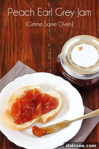 A hand holding a peach over a basket of fresh peaches