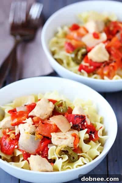 Slow Cooker Chicken Cacciatore served with egg noodles, garnished with fresh herbs.