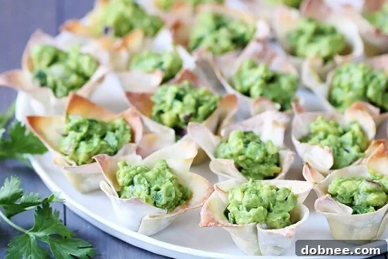 Stacked Guacamole Wonton Cups with a lime wedge