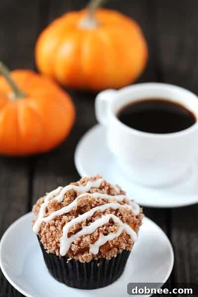 Harvest Pumpkin Crumble Muffins 3 Close-up of freshly baked Pumpkin Streusel Muffins with glaze, highlighting the cinnamon streusel topping.