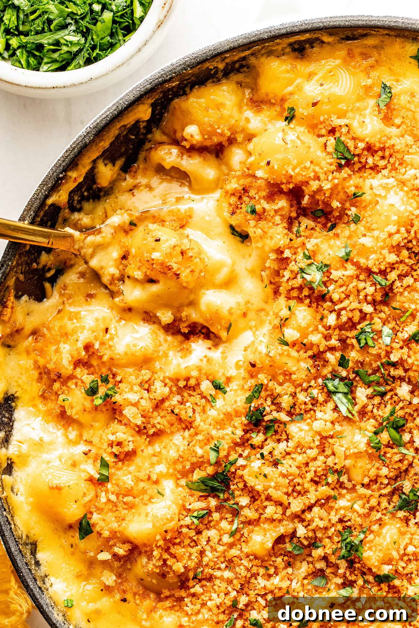 A wider shot of the baked mac and cheese on a rustic table.