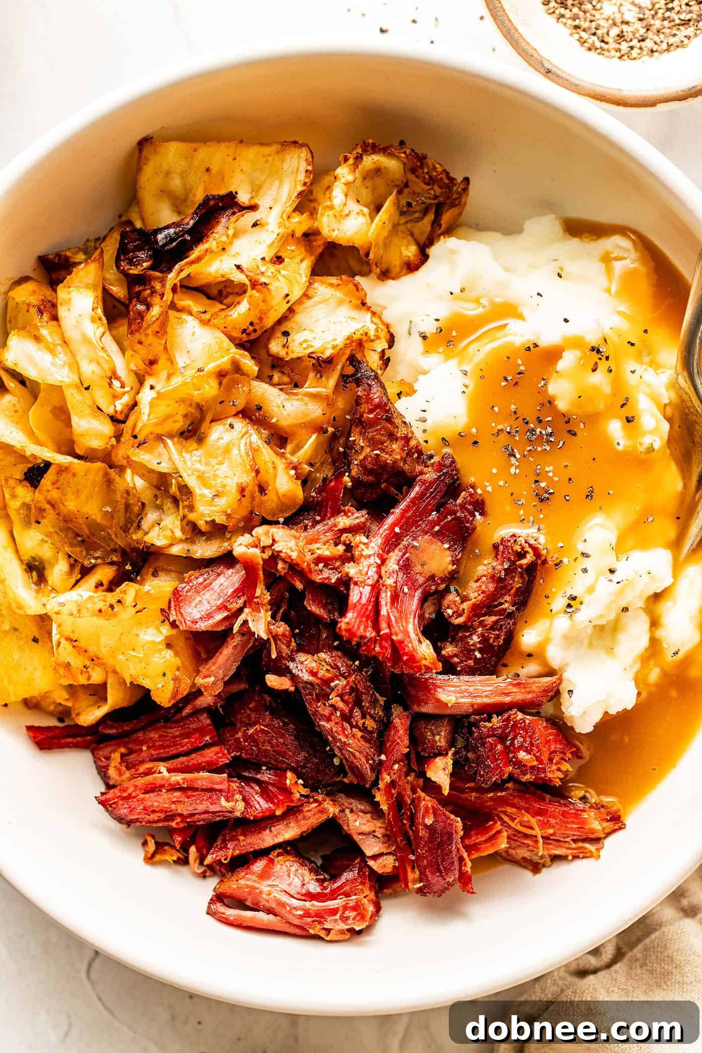 Crispy Carnitas-Style Corned Beef, shredded and broiled to perfection, served with gravy.