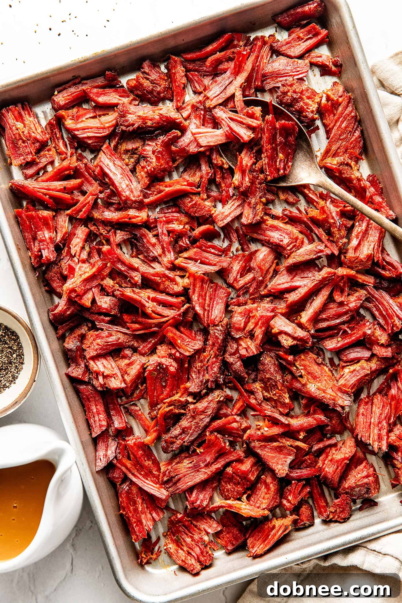 A close-up shot of crispy corned beef in a bowl, with a rich gravy.