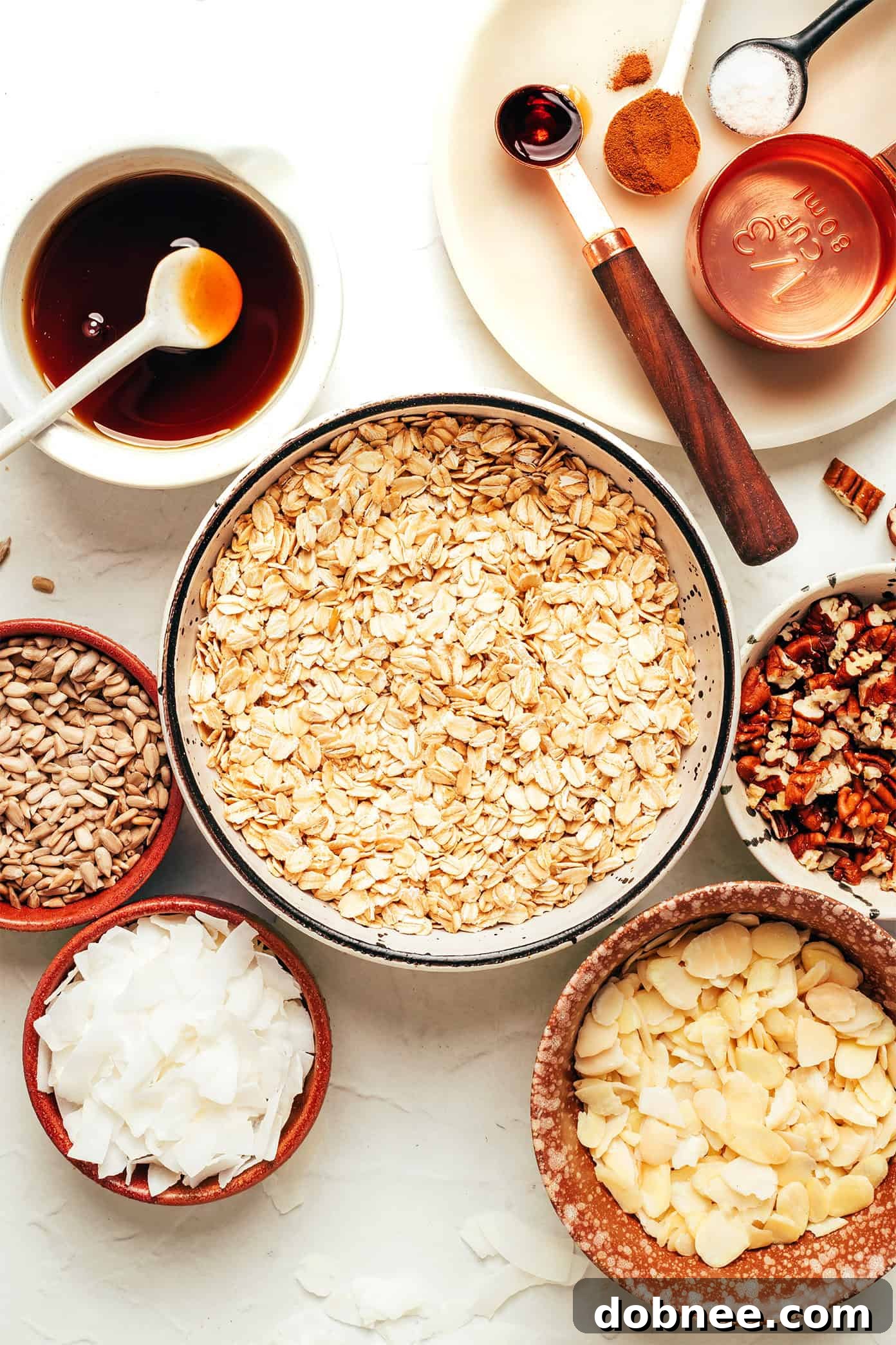 A top-down shot of golden air fryer granola in a large serving bowl, with some clusters visible.