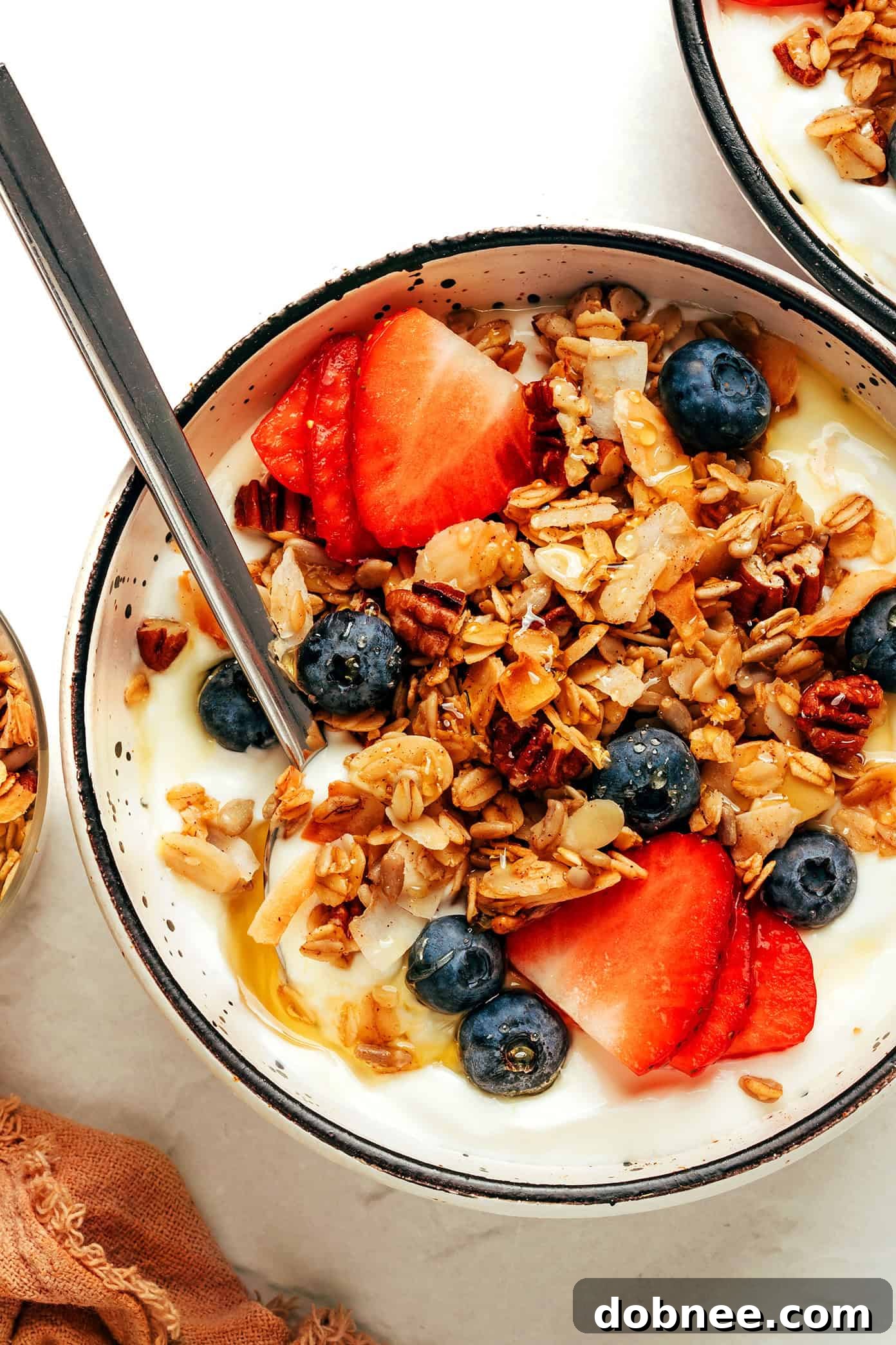 A bowl of fresh air fryer granola with a sprig of mint, ready to be served.