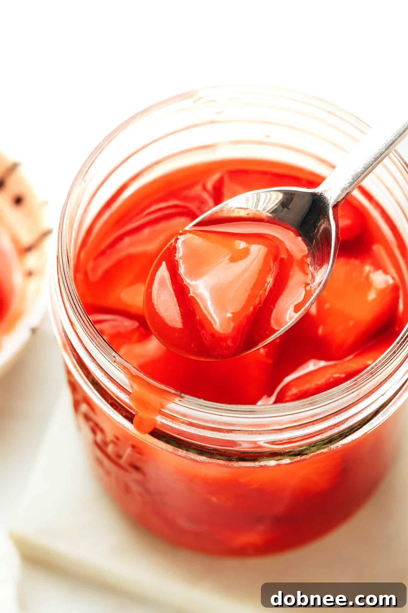 A bowl of fresh strawberries, sugar, and lemon, ready for making sauce.