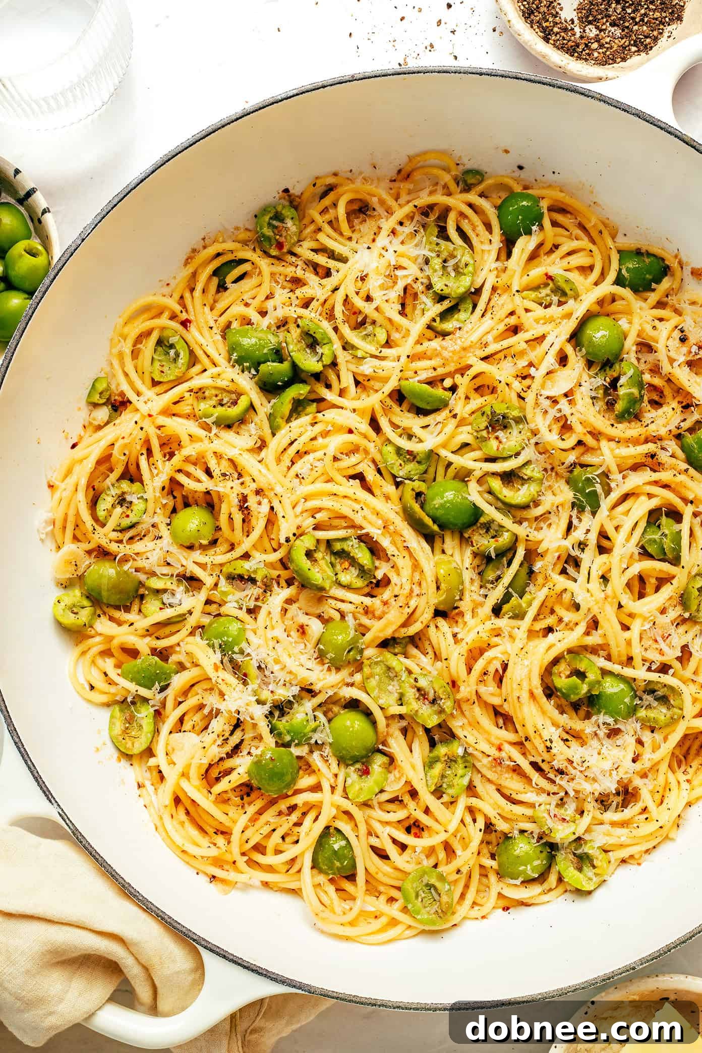 A beautiful top-down shot of Dirty Martini Pasta in a white bowl, garnished with parsley.