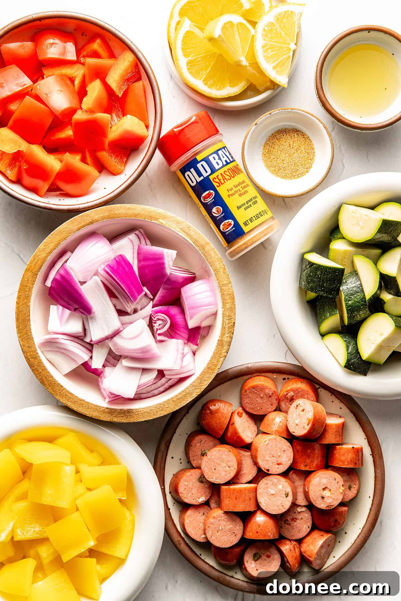 Close-up shot of the seasoned raw vegetables and sausage before being cooked in the air fryer.